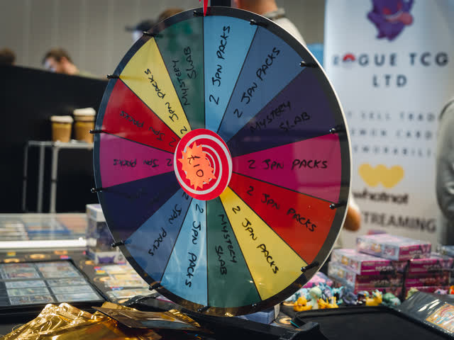 A prize wheel set up at the front of a vendor stand.