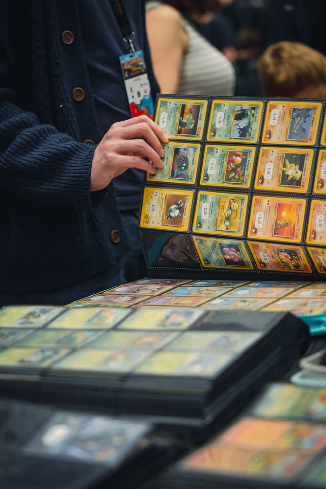 A collector holding up a binder page of vintage cards to the light.