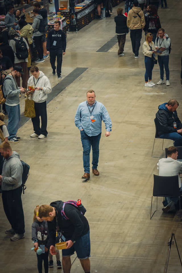 A man walking back down the central aisle with his shopping, the hall opening out behind him.