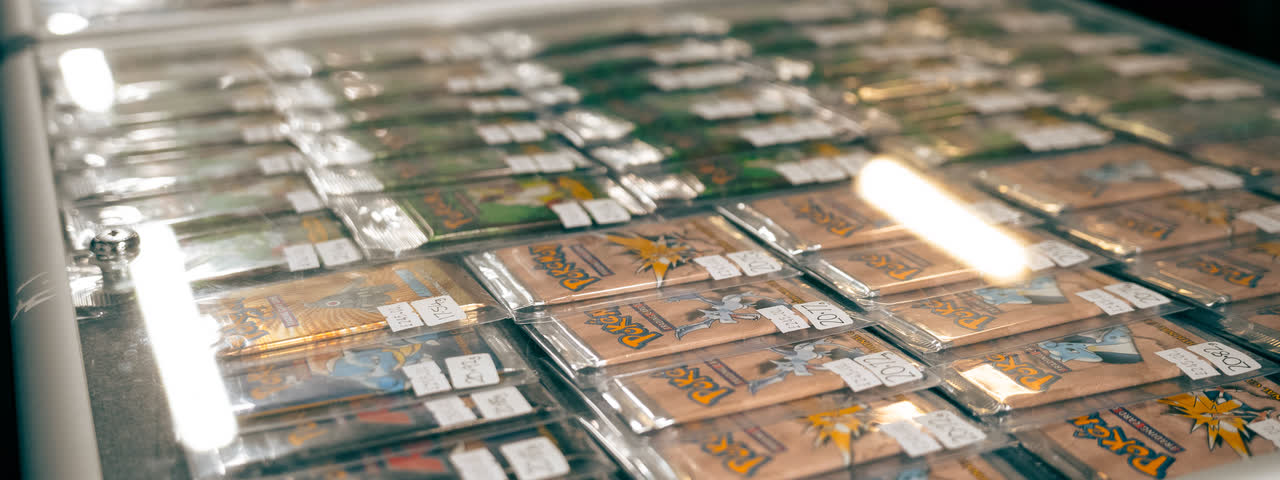 A glass case full of graded slabs in neat rows, the light catching the cases.