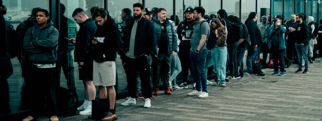 The queue outside, lined up against the glass wall of the venue.