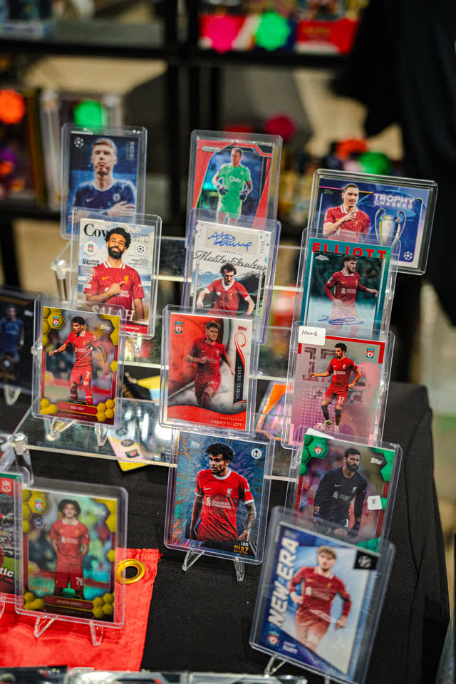 Football cards in top loaders on a display stand.