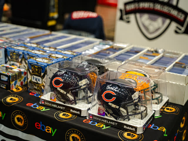 Signed mini American football helmets in cases in front of boxed sports cards.