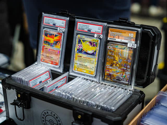 An open carry case of graded Pokemon cards on a vendor table.