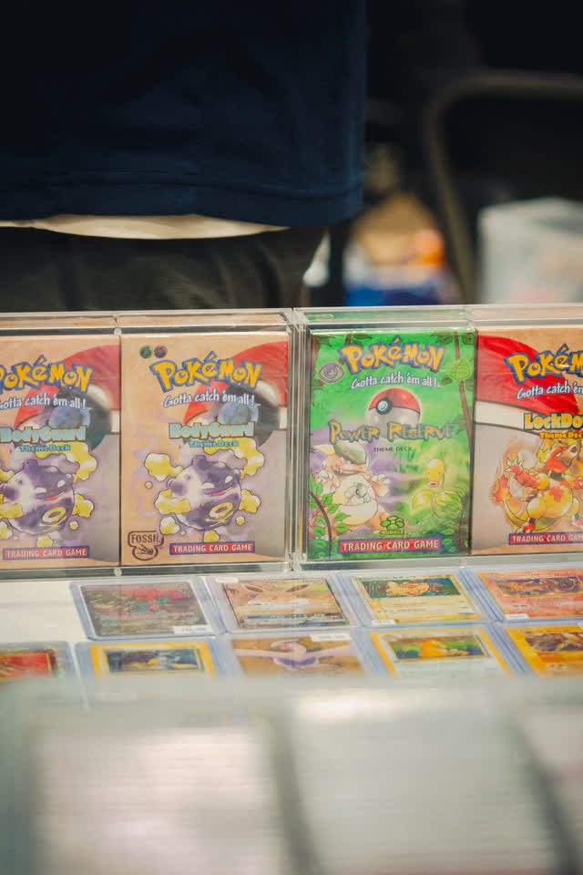 Vintage Pokemon booster packs stood up behind a case of cards.