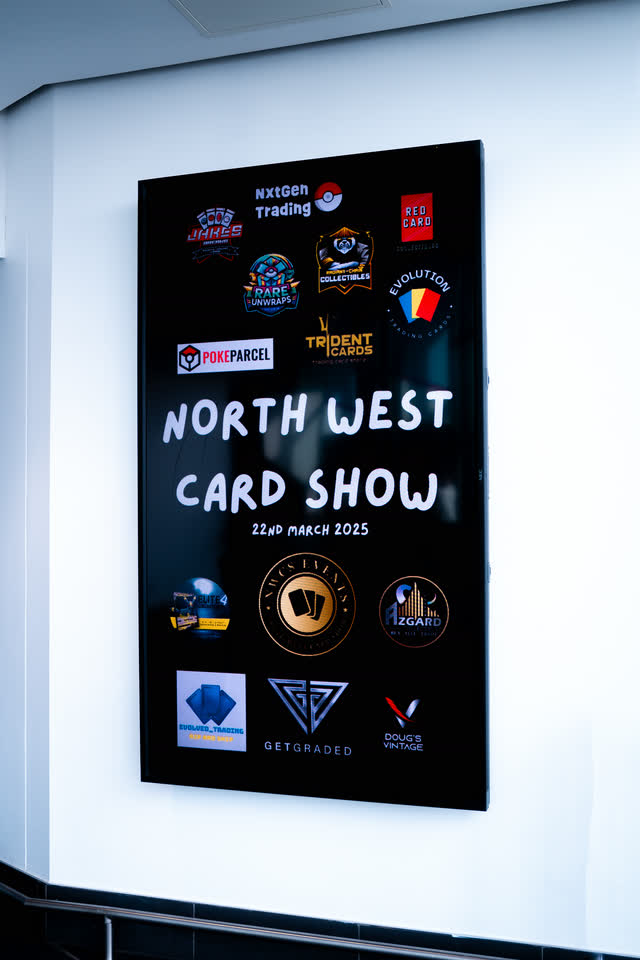 A North West Card Show poster lit on a white wall, sponsor logos around the name.
