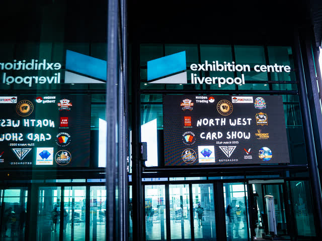 The Exhibition Centre Liverpool entrance with North West Card Show screens lit above the doors.