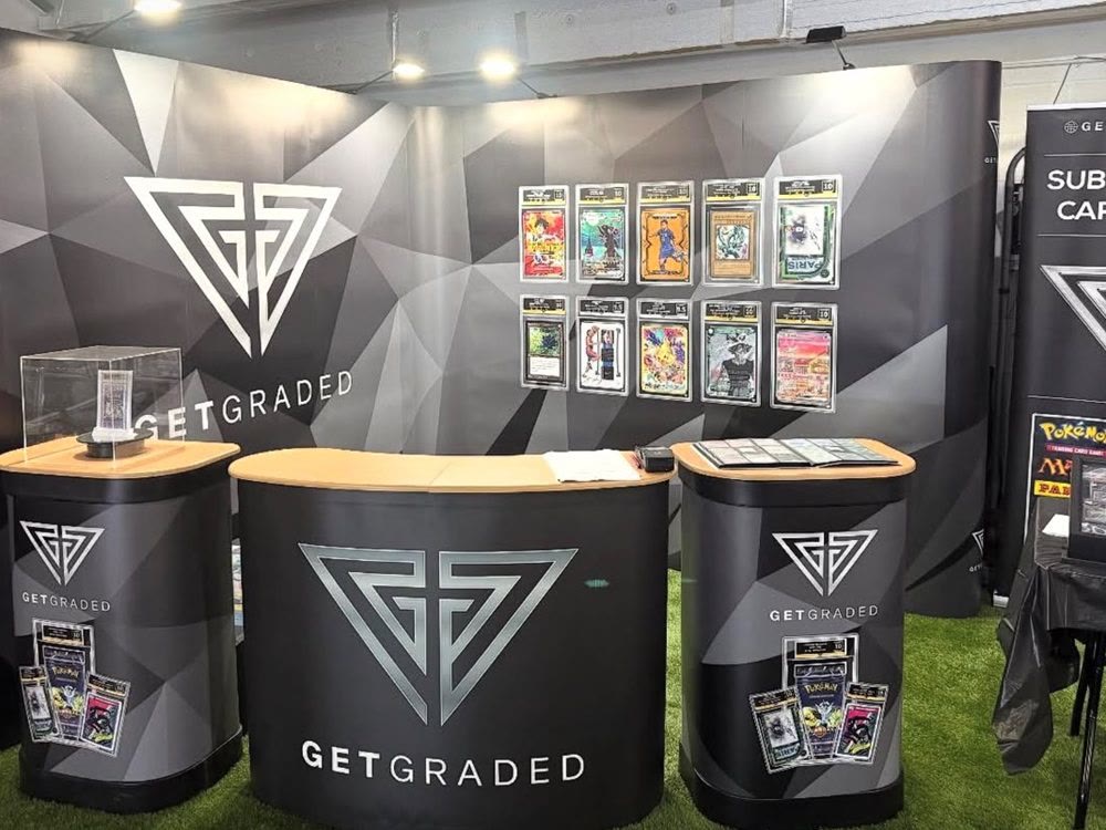 The Get Graded stand, graded cards on the back wall above branded counters