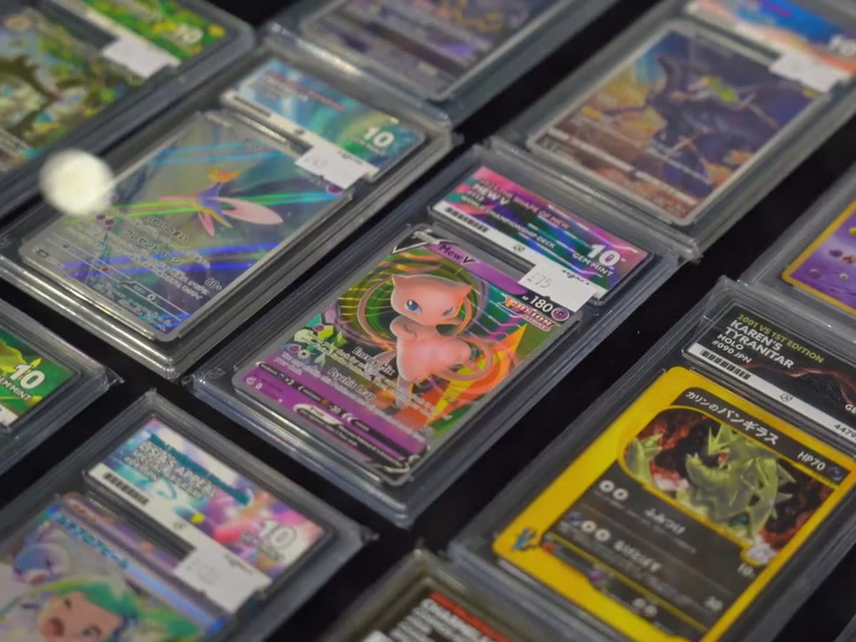 A slow pass over rows of graded Pokemon cards catching the light.