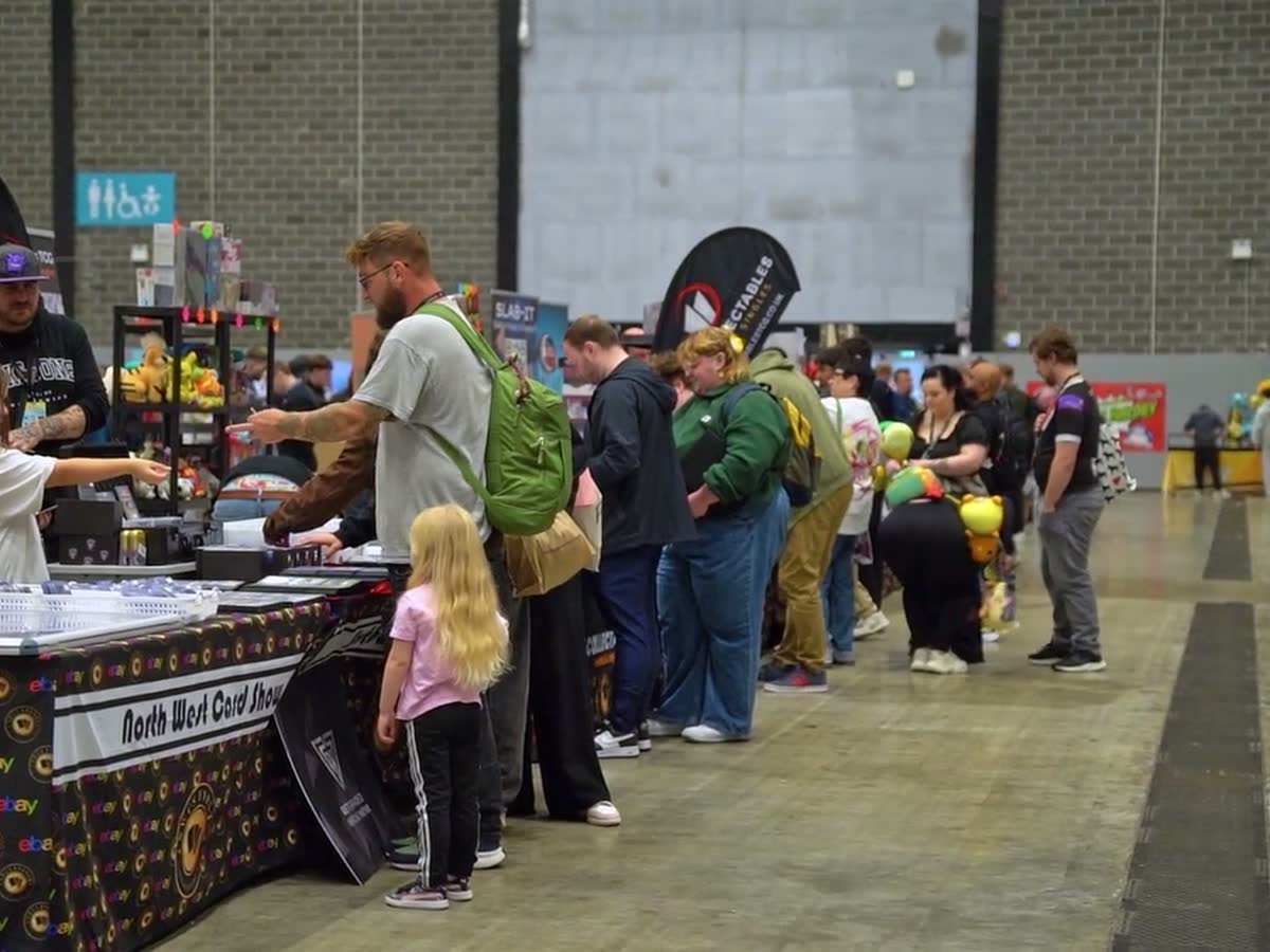 A busy trading table with a queue of collectors stretching away down the hall floor.